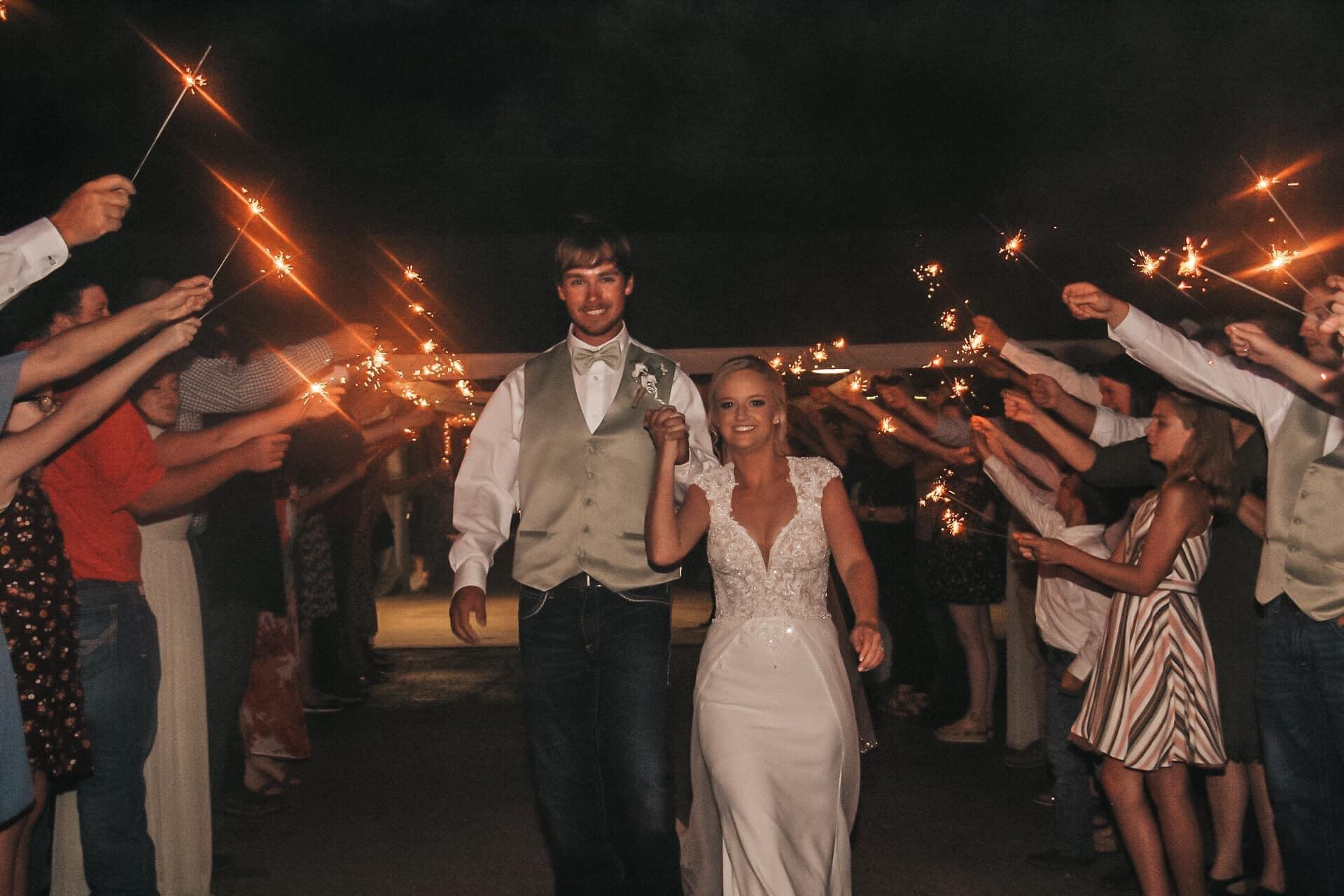 bride and groom exiting while guests have sparklers lit