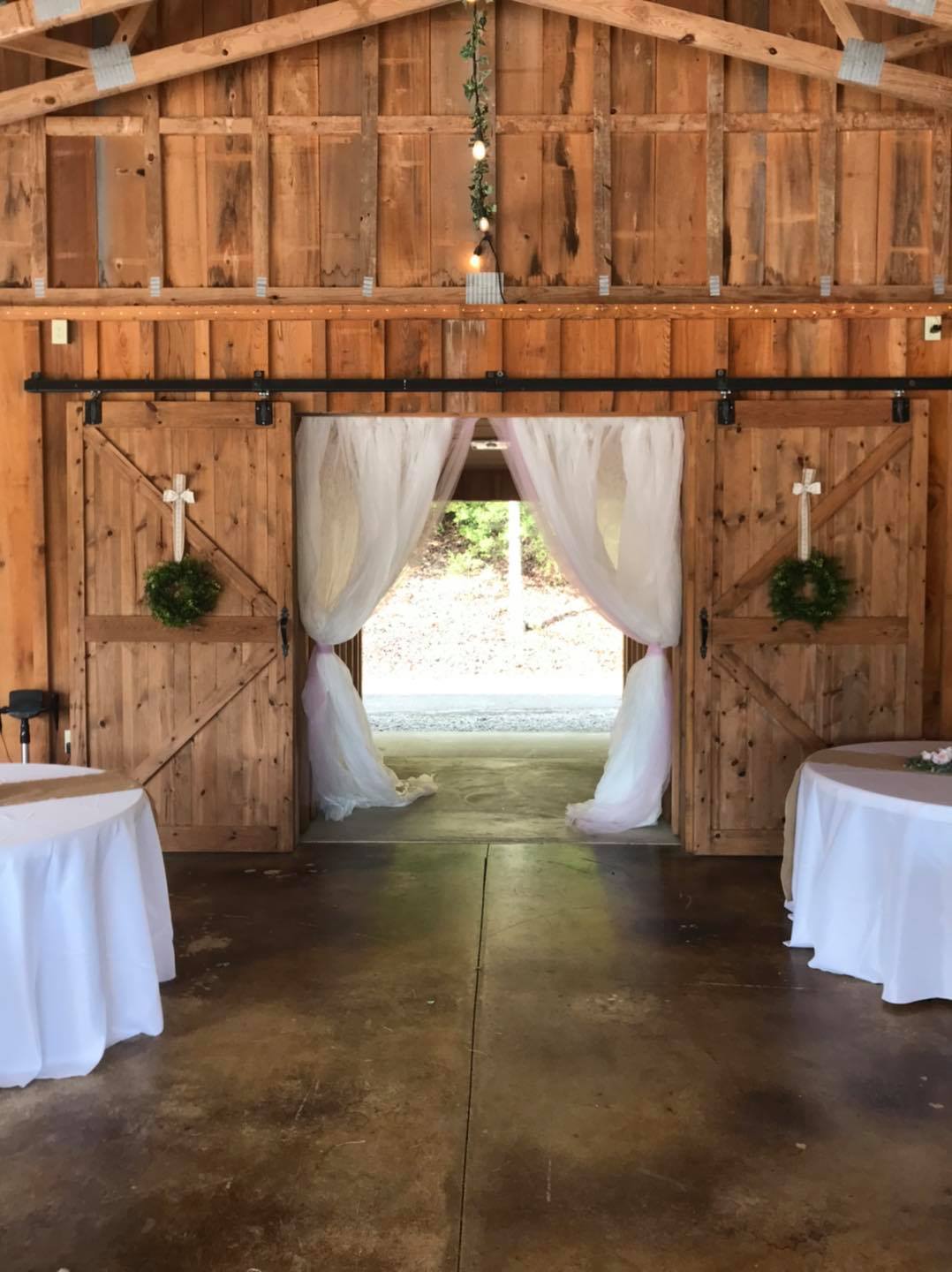 wedding entrance lined with white curtains and barn doors
