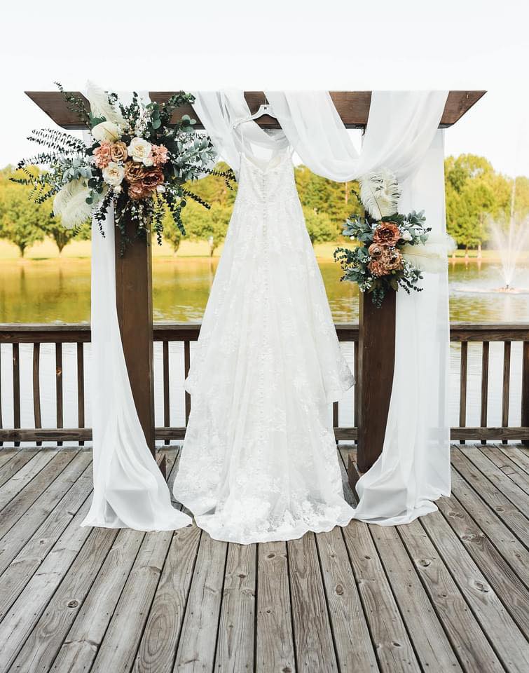 detail shot of wedding dress hanging on arch