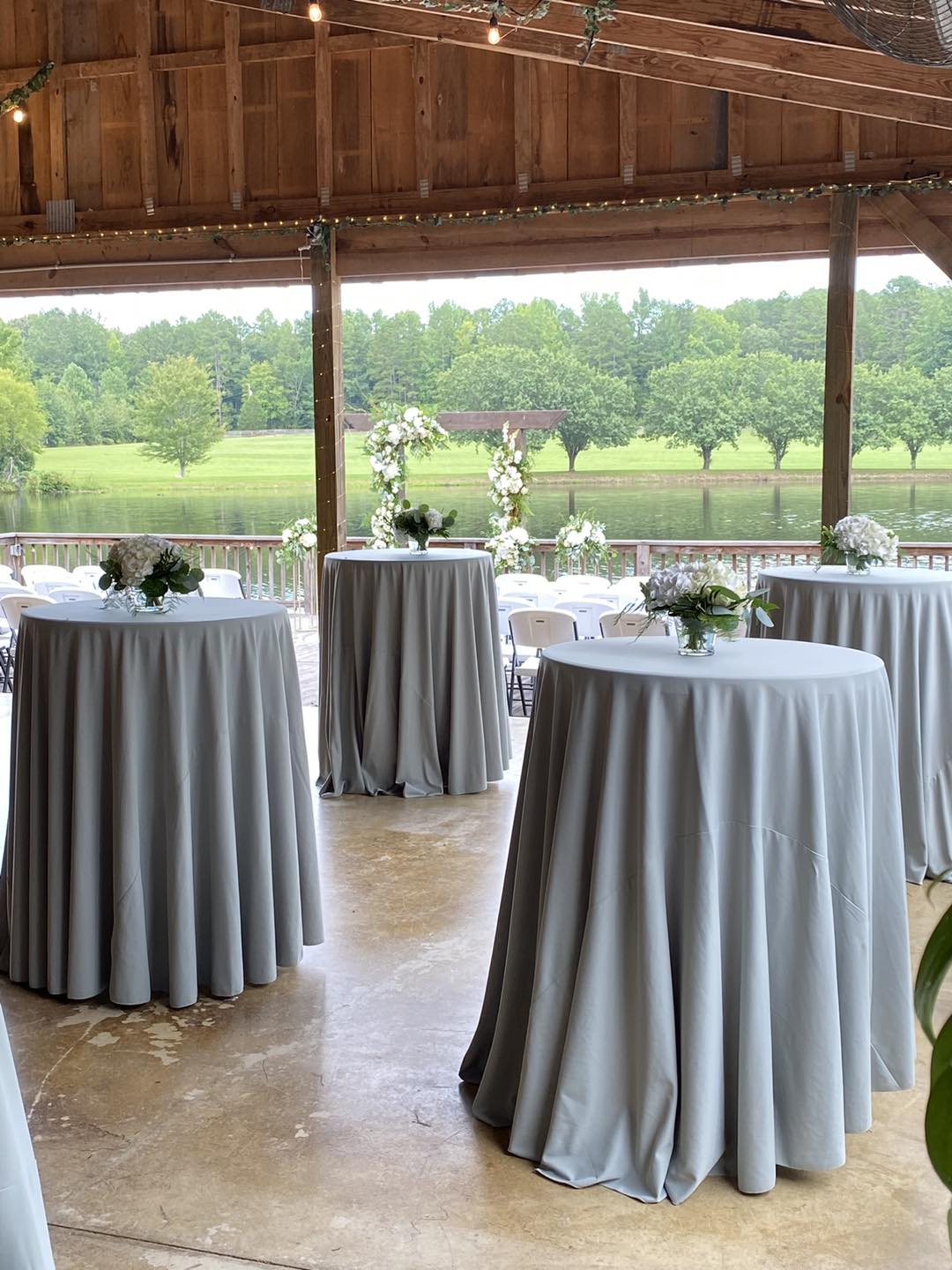 standing reception tables with gray tablecloths