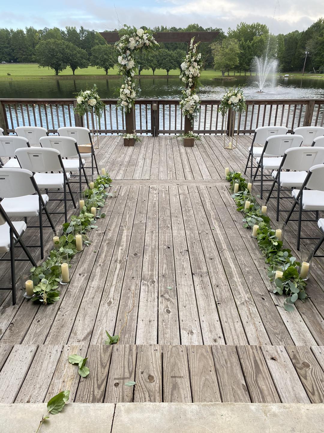 wedding aisle lined with candles and greenery