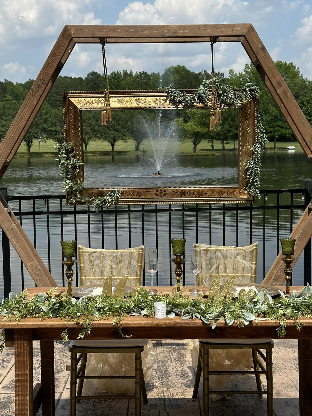 bride and grooms wedding reception table with gold and green accents