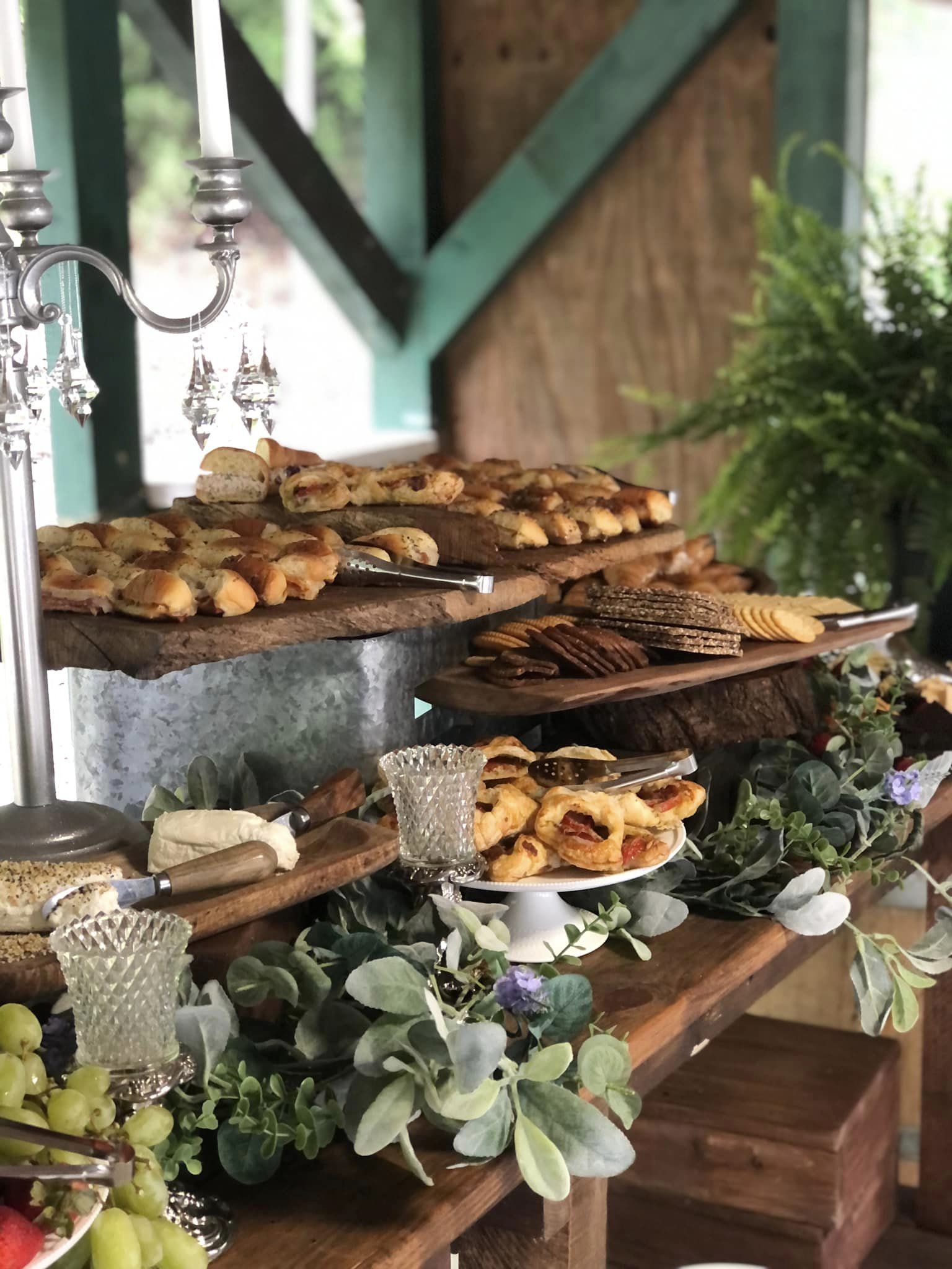 finger food table decorated with greenery and crystals