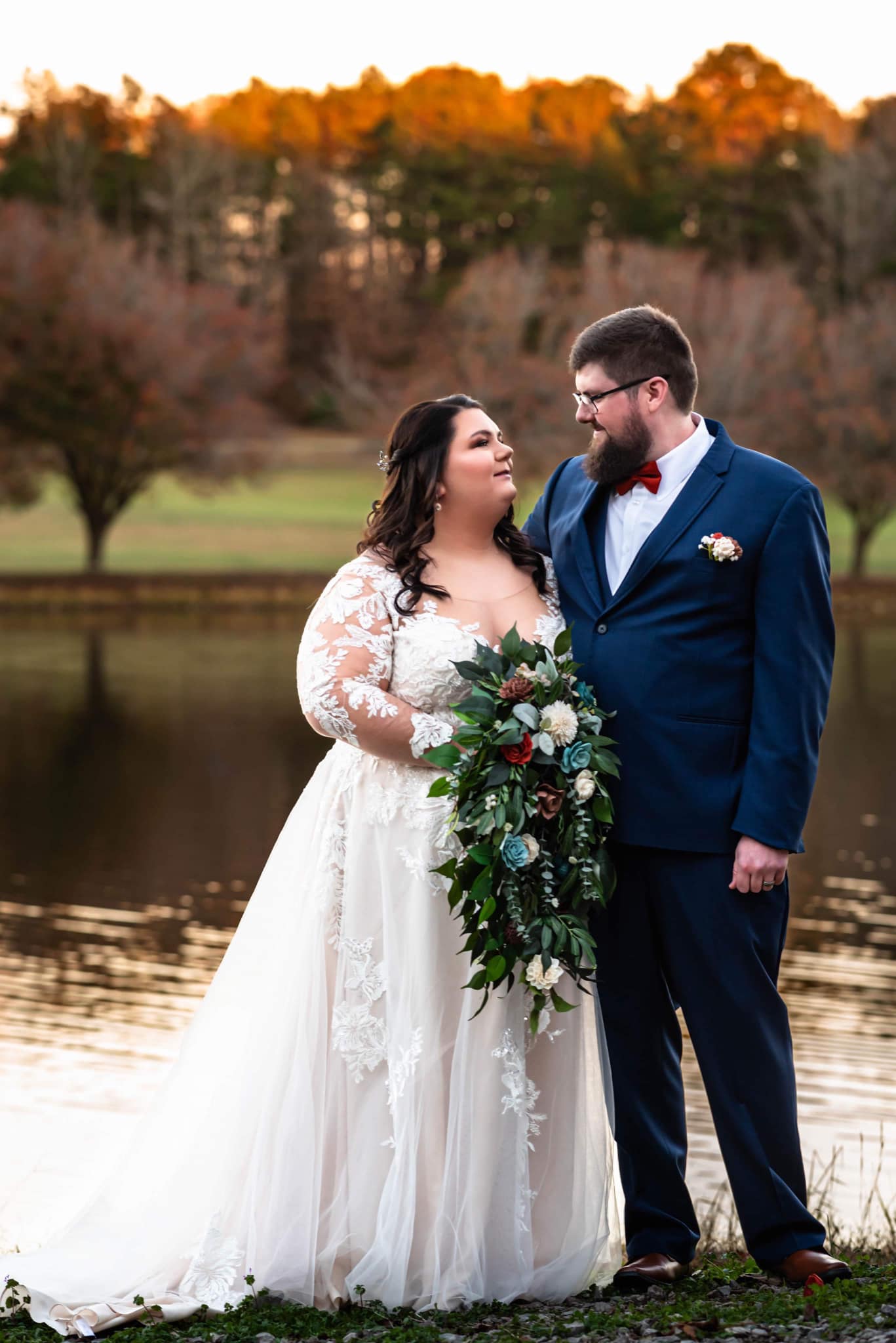 couple looking at each other while bride holds summer flowers