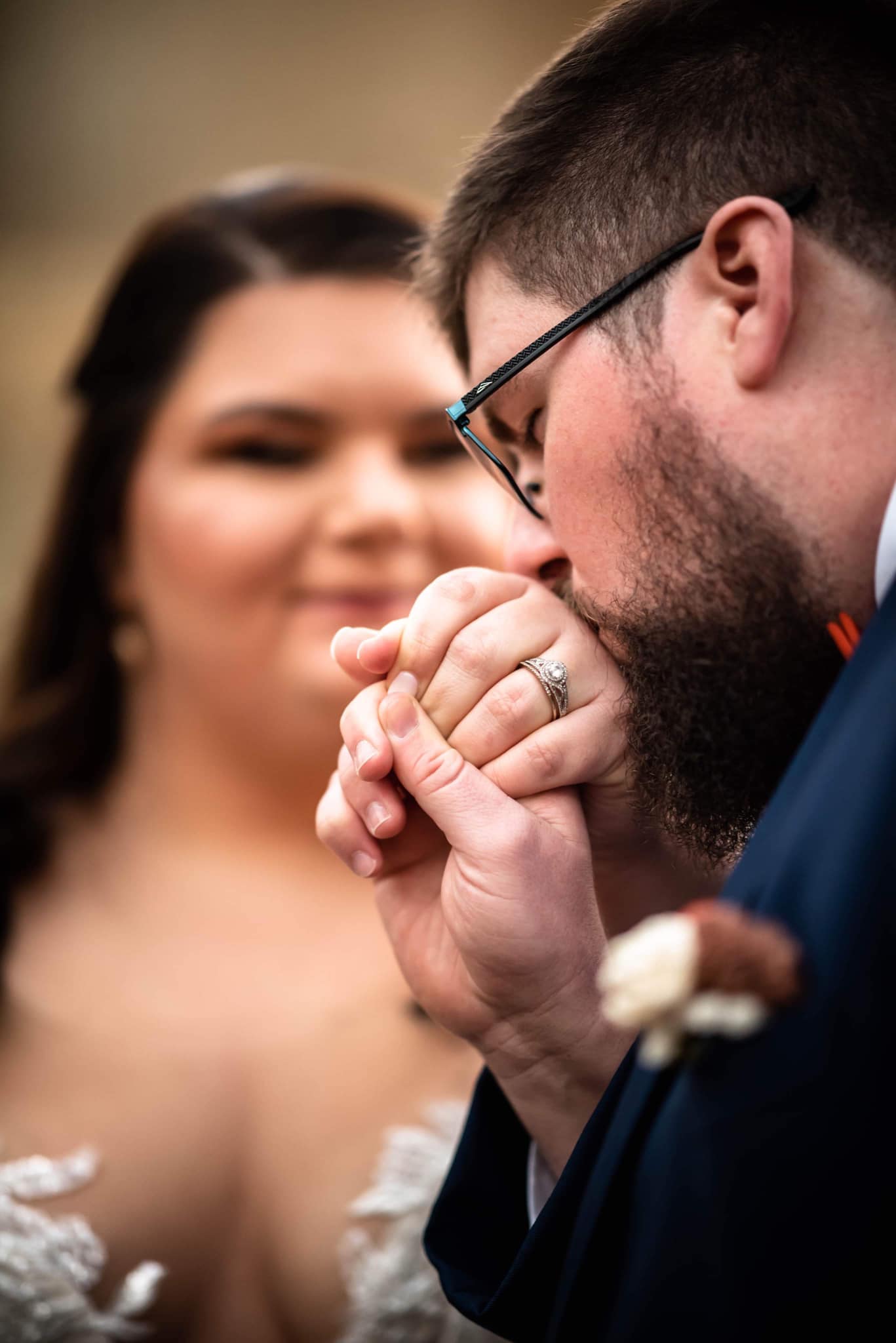 groom kisses brides hand